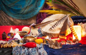 A tabletop composition of the tools used by Clarissa Wrightson. Her shaman's drum, a Tibetian singing bowl and crystals.